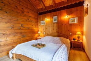 A wooden room with a bed, two bedside tables, and wall-mounted lamps. - Chalet l'Echaillon - Ormelune (SAINTE FOY TARENTAISE)