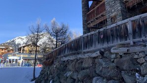 A wooden building with a stone base, a balcony, and a stone wall. - DU PRAZ - LA GRANDE OURSE (SAINTE FOY TARENTAISE)