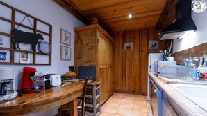 A kitchen with wooden cabinets, a wooden ceiling, and a tiled floor. - DU PRAZ - LA GRANDE OURSE (SAINTE FOY TARENTAISE)