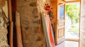 Ein rustikaler Innenraum mit Steinwand, Holzboden und Fliesenboden.