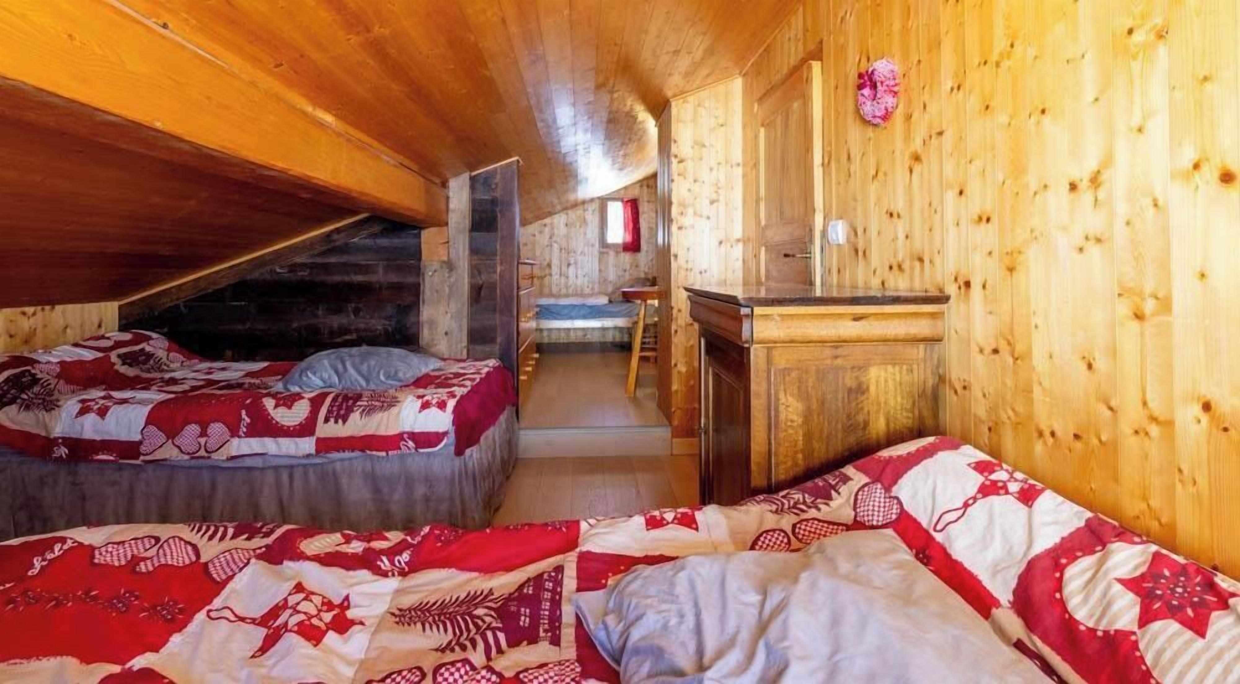 Une cabine équipée de deux lits, d’un bureau en bois et d’une petite kitchenette.