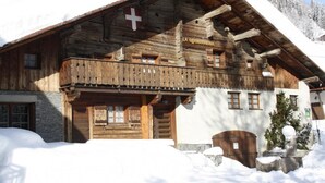 Una cabaña de madera con balcón, una bandera suiza y un letrero que dice "LA GRANPREMIEN".