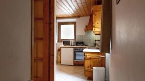 A narrow hallway leading to a kitchen with wooden cabinets and a tiled floor. - Le Myosotis - VAL CENIS (VAL CENIS)