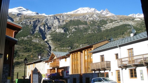 A mountain view with a building featuring wooden balconies and a signboard. - Le Myosotis - VAL CENIS (VAL CENIS)