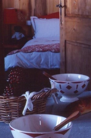 A wooden room with a bed, a nightstand, and a wicker basket.