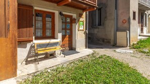 A building with a wooden balcony, a bench outside, and a sign indicating it's a gîte. - LES CAMPANETTES 1st floor (PRALOGNAN LA VANOISE)