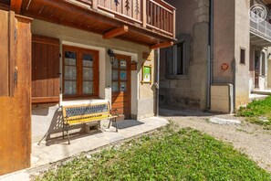 A building with a wooden balcony, a bench outside, and a sign indicating it's a gîte. - LES CAMPANETTES 1st floor (PRALOGNAN LA VANOISE)