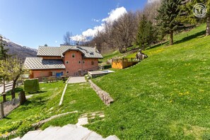 A house with a sloped roof, a stone staircase, and a garden with a wooden deck. - LES JONQUILLES - VALLOIRE (VALLOIRE)