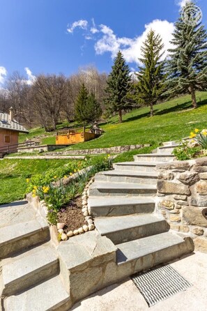 A stone staircase leading up a hill with a garden at the top.