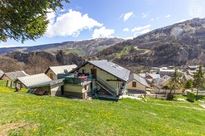 A mountain village with traditional houses, a prominent house with a balcony, and a valley with mountains in the background. - LES JONQUILLES - VALLOIRE (VALLOIRE)
