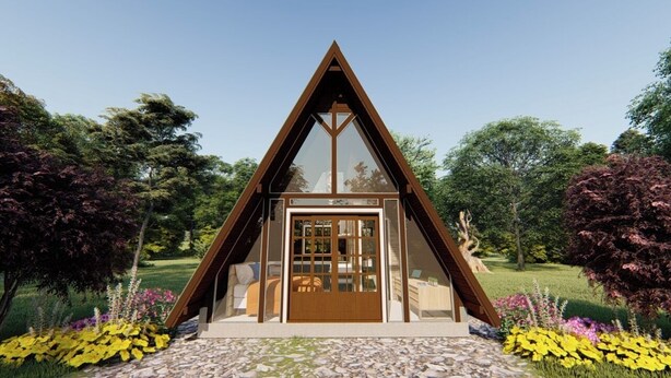 Un bâtiment de forme triangulaire, doté d’une façade en bois et d’une grande porte vitrée, entouré d’un jardin où poussent diverses plantes et fleurs.
