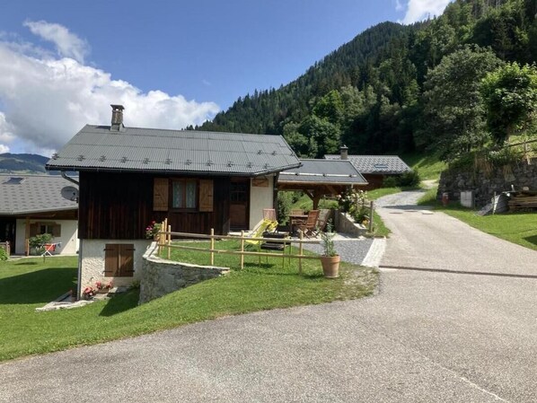 A rustic mountain lodge with a stone foundation, wooden exterior, and a gravel driveway. - LA PACHONNEE - BEAUFORT ARECHES (BEAUFORT ARECHES)