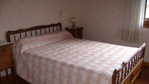 A single bed with a striped bedspread, a nightstand with a lamp, and a patterned rug. - LE CHAR - LA GIETTAZ (LA GIETTAZ)