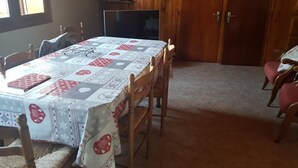 A dining area with a table covered in a patterned tablecloth, surrounded by wooden chairs. - LE CHAR - LA GIETTAZ (LA GIETTAZ)