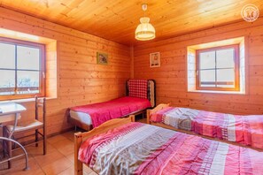 Une cabane en bois avec deux lits, une table et des chaises.