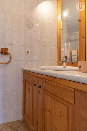 A bathroom with a wooden vanity, a mirror, and a towel ring. - LE LAGOPEDE - AUSSOIS (AUSSOIS)