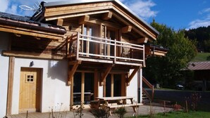 A wooden chalet with a balcony, a wooden deck, and a door. - LE REFUGE DU BACHAL N°1 (NOTRE DAME DE BELLECOMBE)