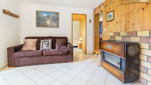 Ein Wohnzimmer mit braunem Sofa, Kamin und einem Bild an der Wand.