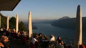 An outdoor dining area with tables and chairs overlooking a lake and mountains. - L'ARCHE - RUFFIEUX - Gîte (RUFFIEUX)