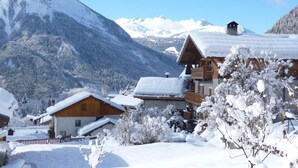 A snow-covered mountain village with wooden buildings and a clear sky. - LE CHENET DES PIERRES (CHAMPAGNY EN VANOISE)