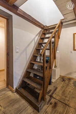 Un escalier en bois dans une pièce aux murs blancs et au plancher en bois.