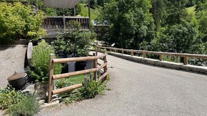 A paved road with a wooden fence, a covered seating area, and a mountain backdrop. - LA COMBE DE MOULIN - PEISEY NANCROIX (PEISEY NANCROIX)