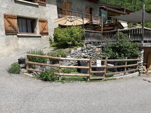 A rustic building with wooden shutters, a stone wall, and a wooden fence. - LA COMBE DE MOULIN - PEISEY NANCROIX (PEISEY NANCROIX)