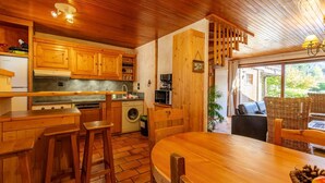 A wooden interior with a kitchen, dining area, and a view of the outdoors.
