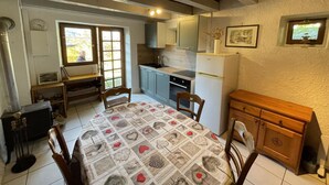 A cozy kitchen with a dining table, chairs, a refrigerator, and a window. - PIERRE BLANCHE - VALMOREL LES AVANCHERS (VALMOREL LES AVANCHERS)