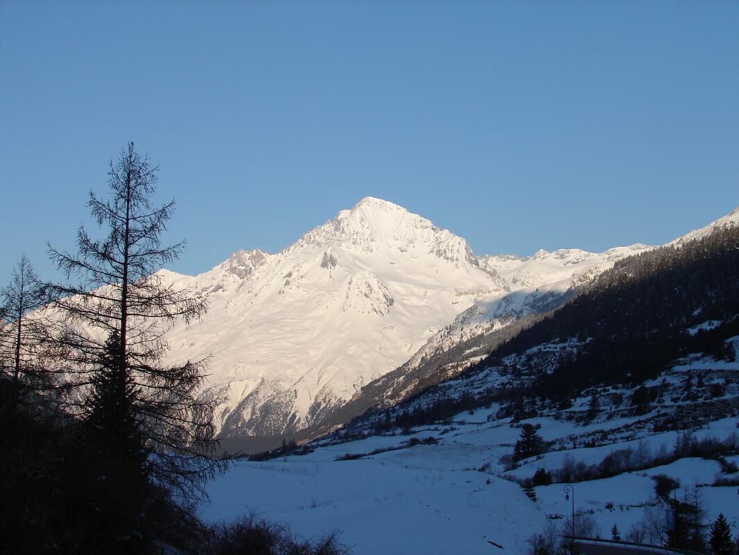 A snow-covered mountain with a clear sky.