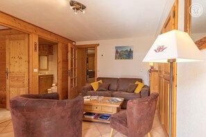 A cozy living room with a sofa, two armchairs, a coffee table, and a lamp.