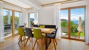 Un comedor con mesa de madera, sillas y vista al exterior.