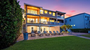 A multi-story building with outdoor seating and a well-maintained lawn. - MarcoWaterfront-BalconyViews-Pool+Spa-Fishing (Marco Island)