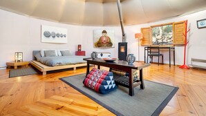 A modern interior with a bed, a dining table, and a sofa.