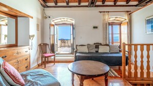 Ein Zimmer mit Holzboden, einem Bett, einem Sofa, einem Tisch und einem Sessel.