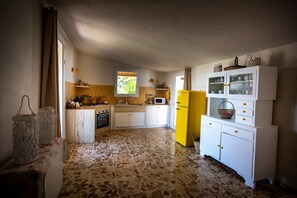 A kitchen with white cabinets, a yellow refrigerator, and a tiled floor. - Holiday Home 'Suite La Barracca' with Sea View, Wi-Fi and Air Conditioning (Marsala)