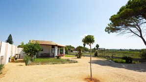A house with a tiled roof, a patio with chairs, and a garden with various plants. - Holiday Home 'Suite La Barracca' with Sea View, Wi-Fi and Air Conditioning (Marsala)