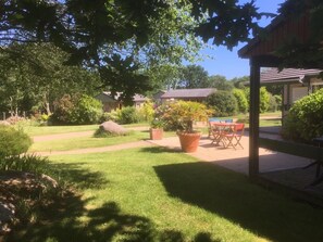 A well-maintained garden with a patio area, a pool, and a covered seating area.