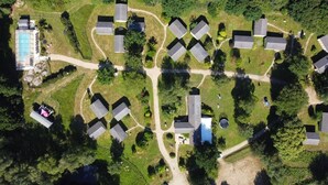 A residential area with multiple detached houses, a swimming pool, and well-maintained lawns. - Apartment 'Chalet Premium 2' with Private Terrace and Shared Garden (Pleumeur-Bodou)