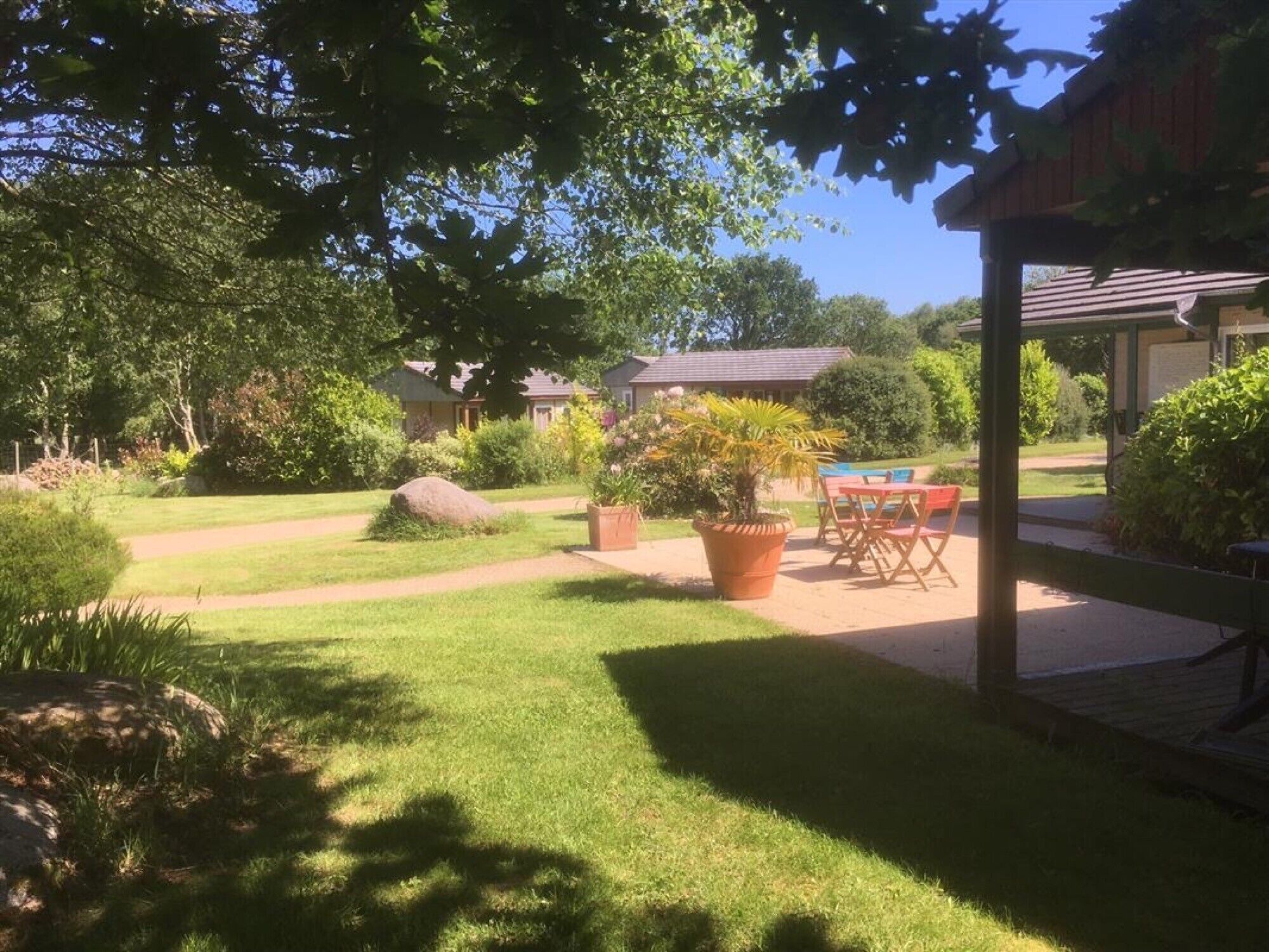 Ein gepflegter Garten mit Terrasse, Pool und überdachter Sitzecke.