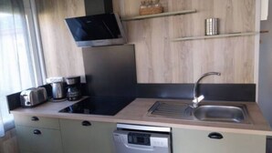 A compact kitchen with a built-in microwave, toaster, coffee maker, and dishwasher. - Apartment 'Chalet Premium 2' with Private Terrace and Shared Garden (Pleumeur-Bodou)
