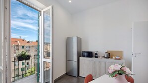 Eine kleine Küche mit Kühlschrank, Mikrowelle und einem Schrank.