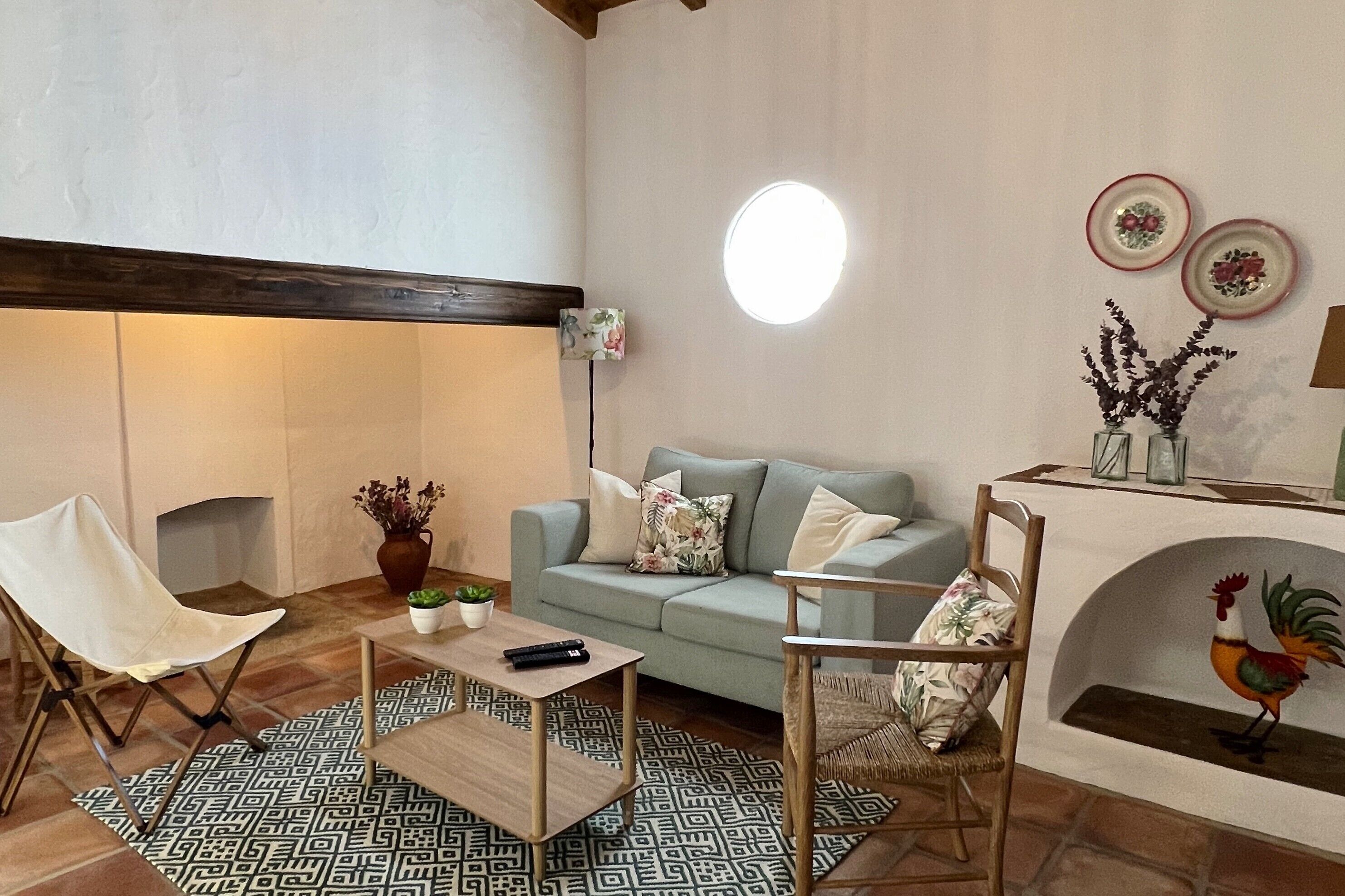 Un salon comprenant un canapé, des fauteuils, une table basse, une cheminée et des éléments de décoration murale.