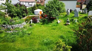 A cemetery with headstones, a yurt, and surrounding greenery. - Seminarhaus Arya Maitreya (Kaufbeuren)