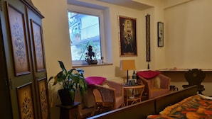 A bedroom with a bed, a desk, a chair, a window, and a potted plant. - Seminarhaus Arya Maitreya (Kaufbeuren)