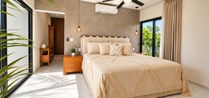A bedroom with a bed, bedside tables, a ceiling fan, and a view of greenery outside. - Villa Alexa: Experience the Adventure! (Akumal)