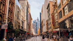 A street with historic buildings, a tram, and pedestrians. - KozyGuru | Haymarket | Chic City Studio (Haymarket)