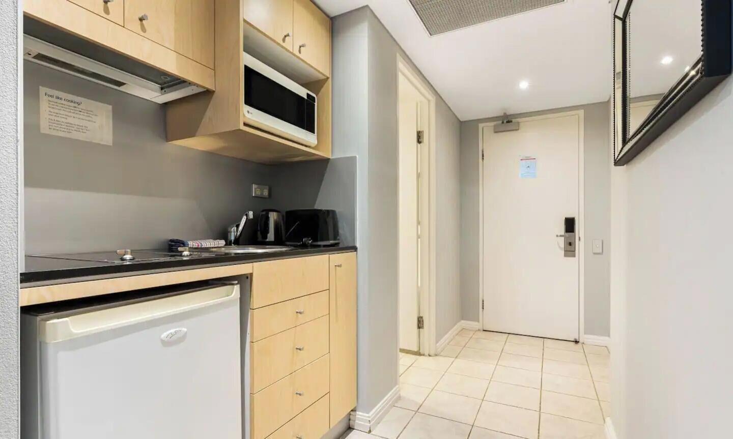 A compact kitchen with a microwave, coffee maker, and a small refrigerator.