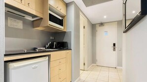 A compact kitchen with a microwave, coffee maker, and a small refrigerator.