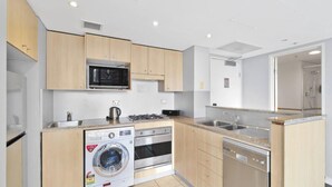Cocina compacta con lavadora, estufa, microondas y lavavajillas.